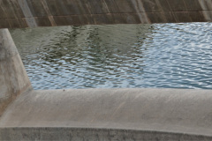 Desde el mirador ubicado a un lado del dique, las tranquilas aguas del pequeño embalse se observan a través del vertedero.