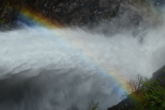 Las pequeñas gotas de agua de la descarga de medio fondo descomponen la luz solar y producen un arcoiris sobre el río de los Sauces.